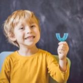 NORMAL-iStockPhoto-1024px-1179986864-300×200-1 Three-year old boy shows myofunctional trainer. Helps equalize the growing teeth and correct bite, develop mouth breathing habit. Corrects the position of the tongue.